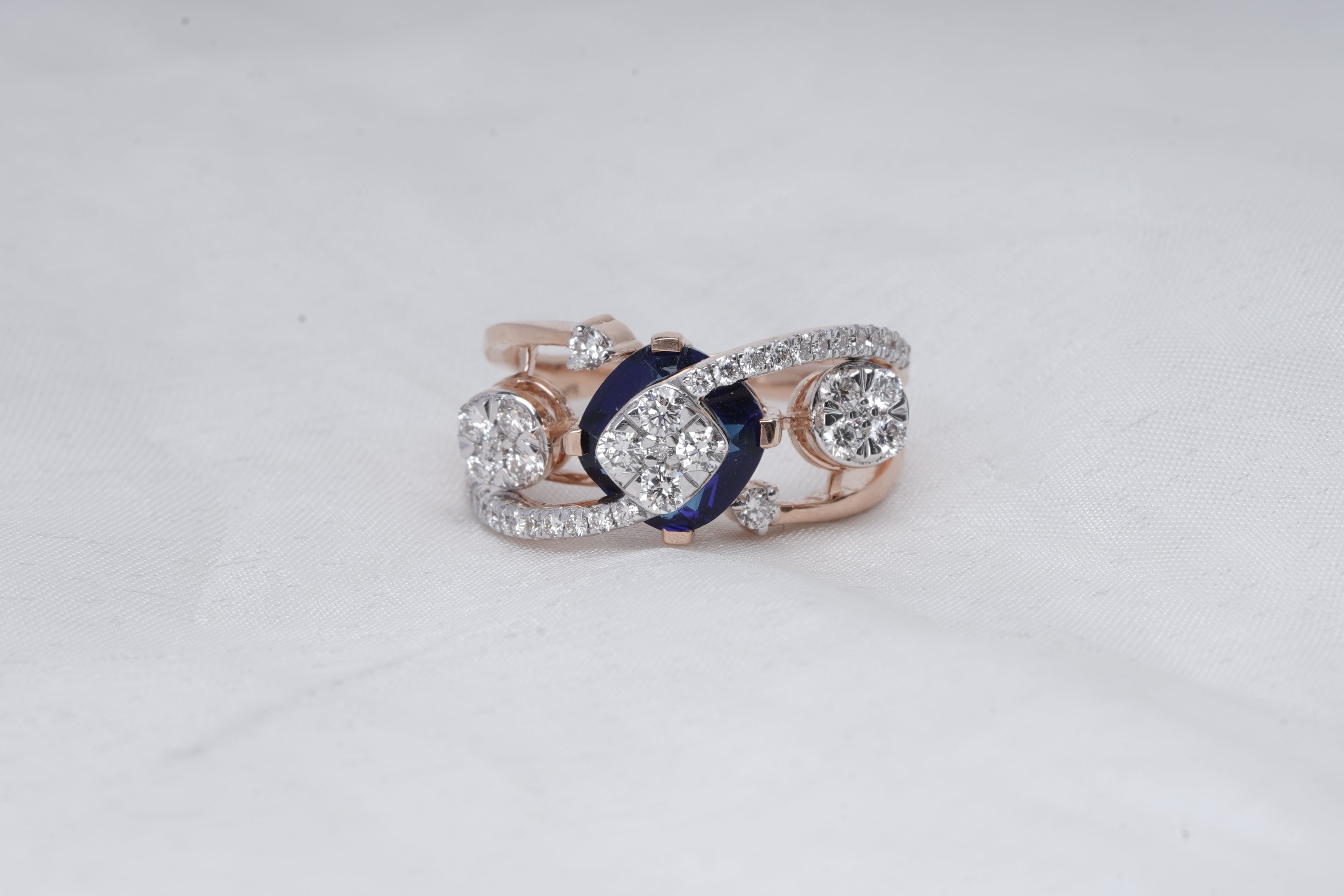 Wave ring with blue sapphire center and diamond clusters 