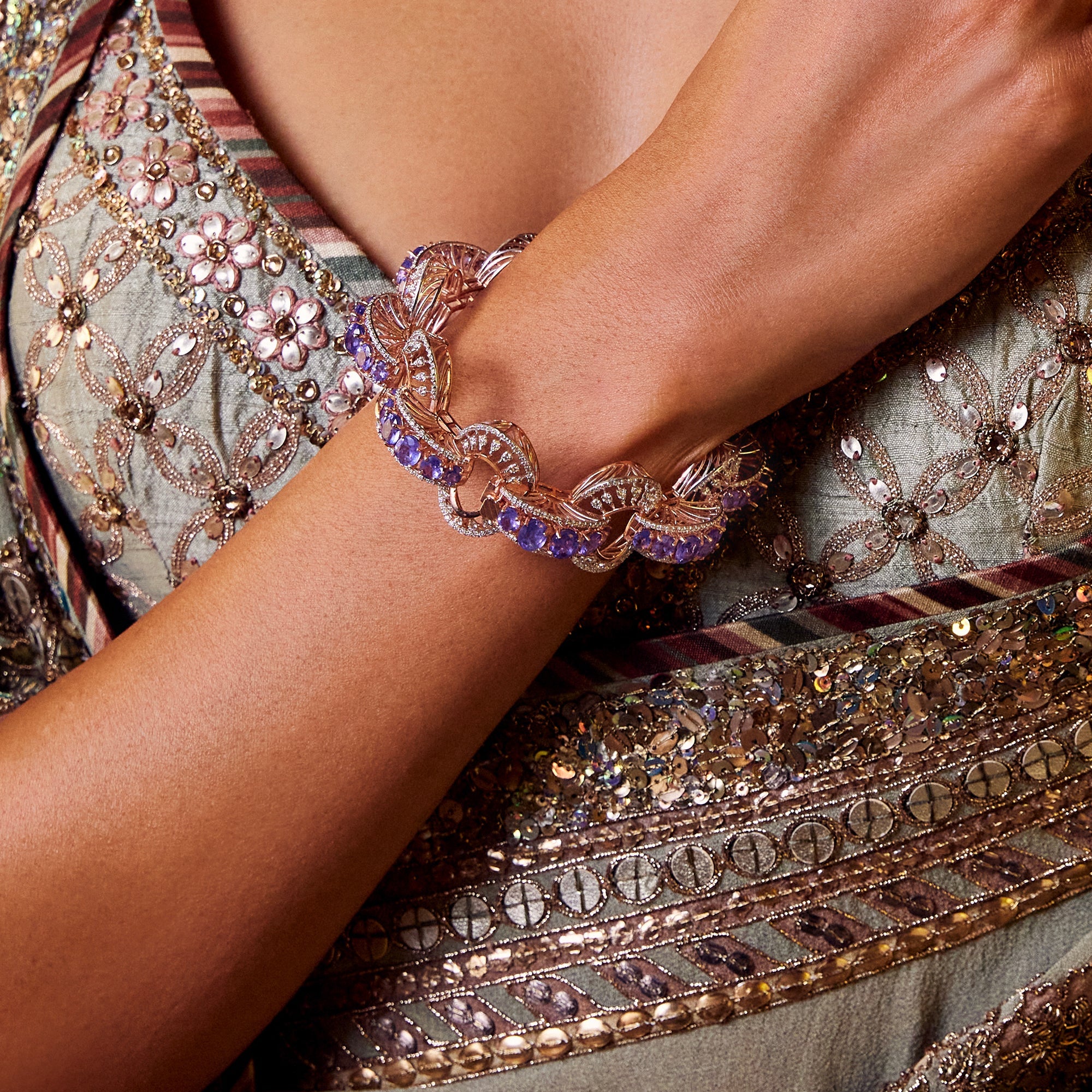 Rose gold bracelet with vibrant violet gemstones and diamond accents in a swirling design