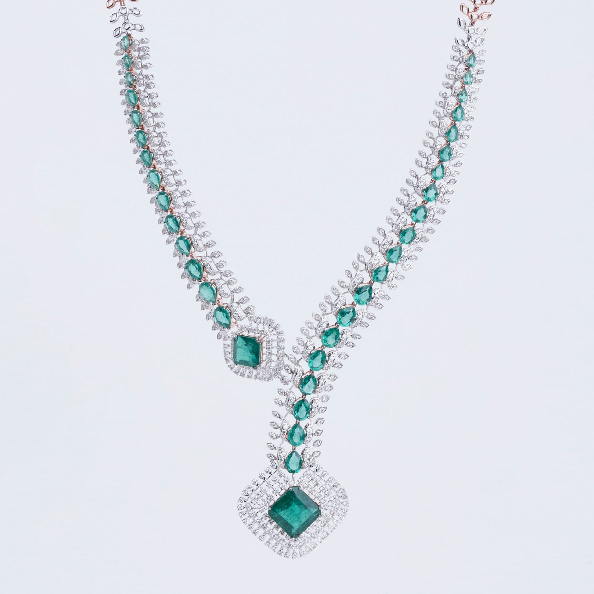 Contemporary necklace set with geometric emerald and diamond patterns, crafted in 14K gold.