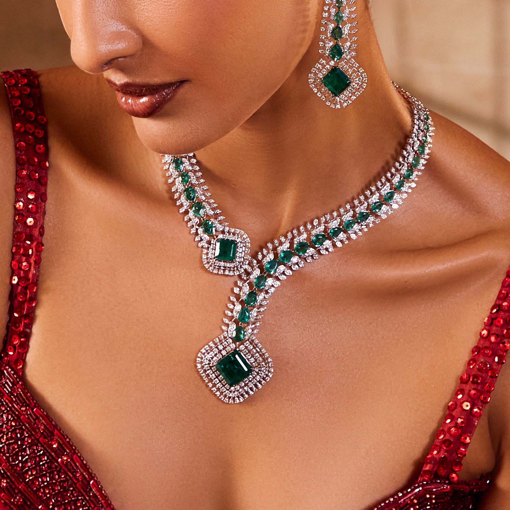 Modern necklace and earring set with asymmetrical emerald and diamond design, in 14K gold.