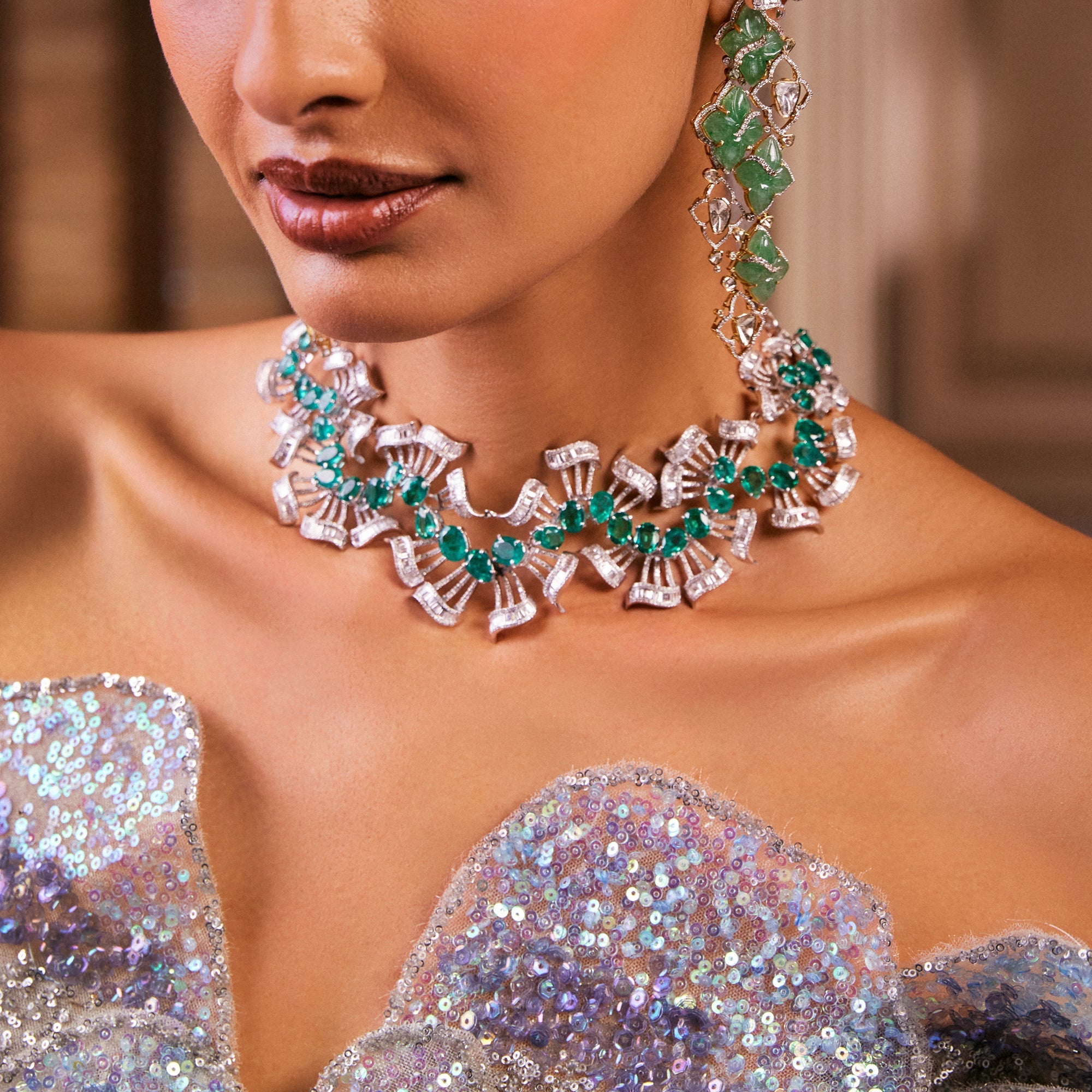 Sleek diamond collar necklace with emeralds and matching earrings in 18K gold, featuring a fan-like design.