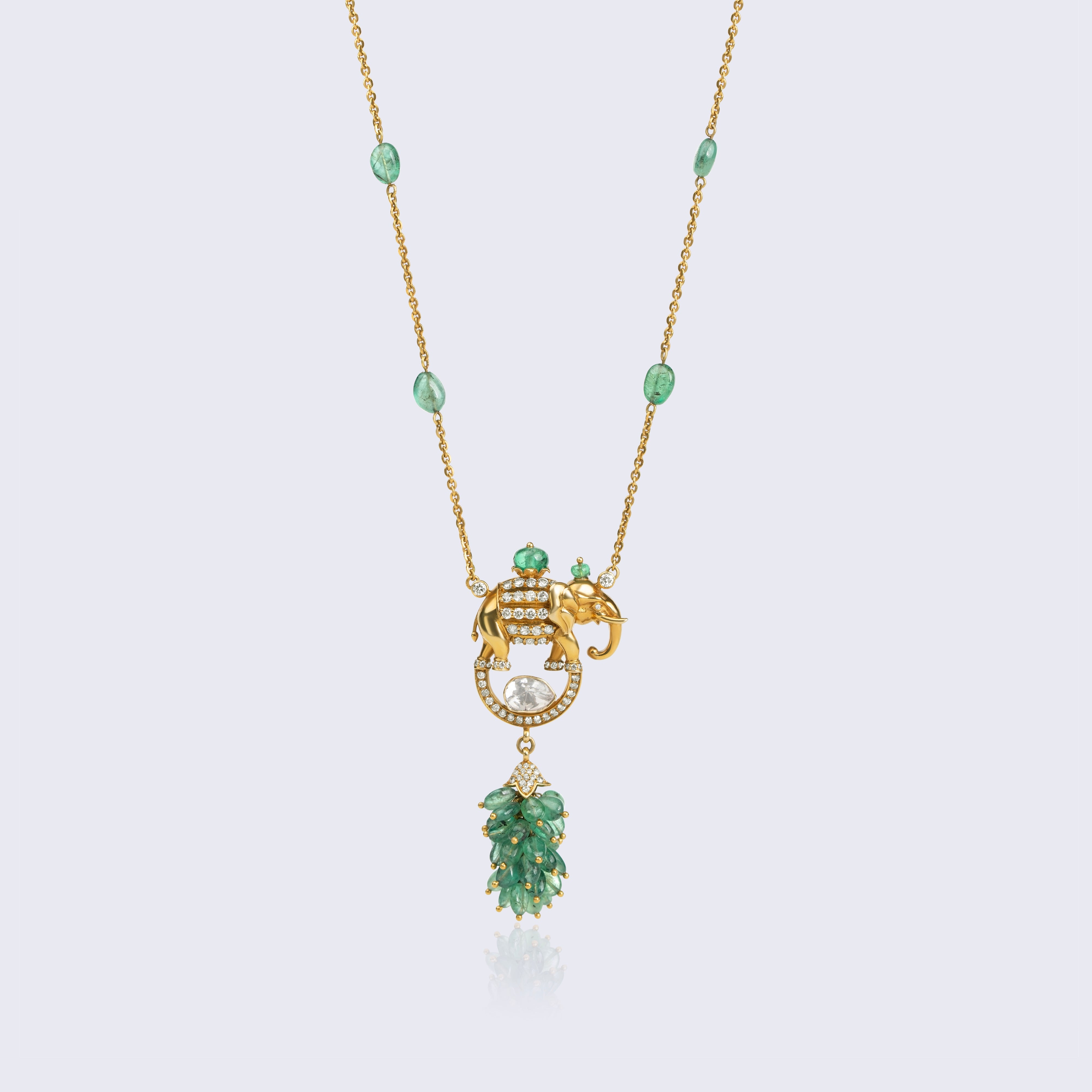 Royal 14K gold elephant polki pendant with emerald bead chain, large polki diamond, and emerald leaf tassel featuring traditional Indian craftsmanship